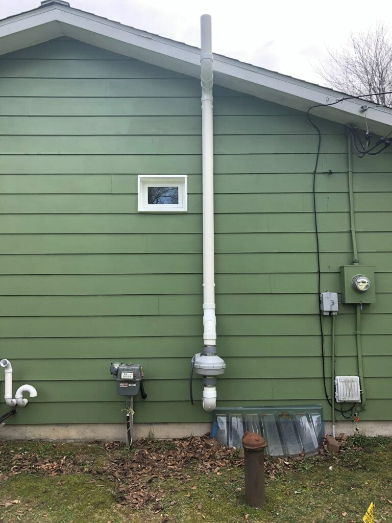 Radon mitigation system on the exterior of a Michigan home.
